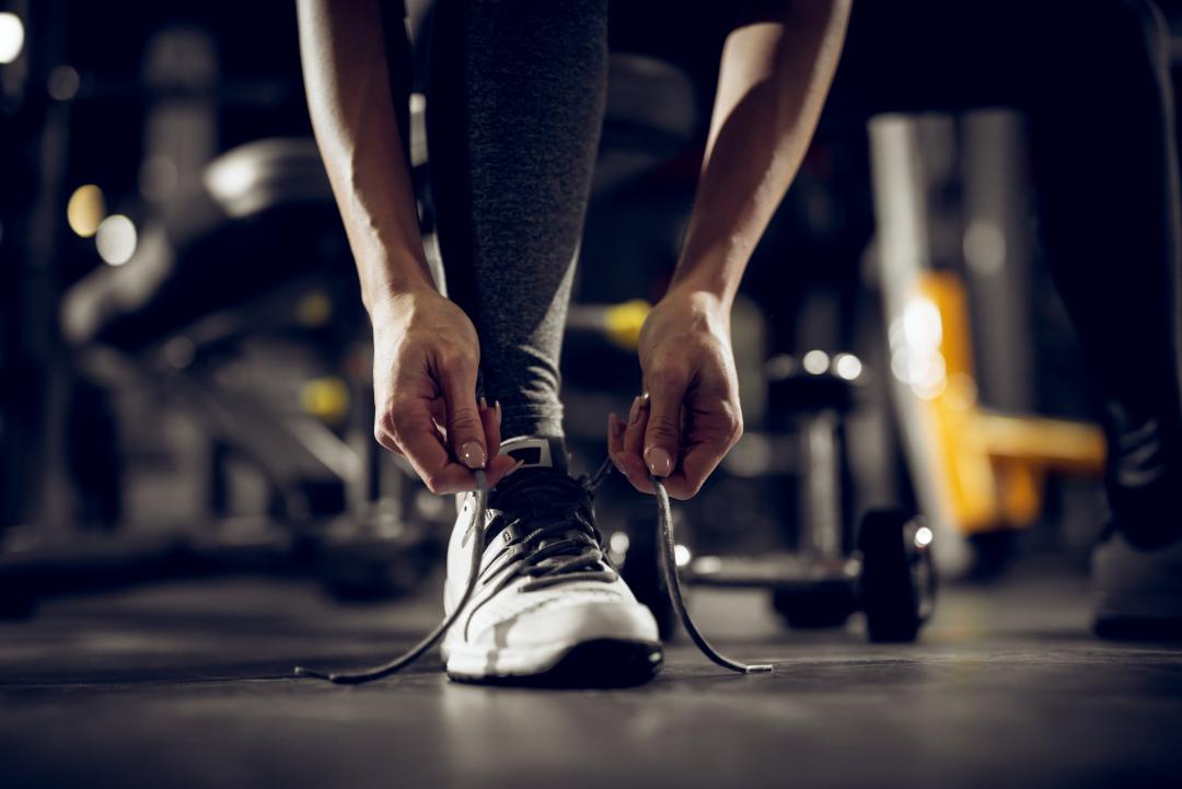 Woman tying her shoe preparing for exercise