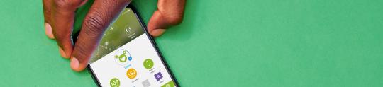 Hand holding a phone with mySugr CGM graph on the screen