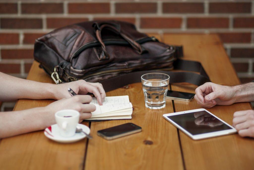 The hands of two people discussing something at a table