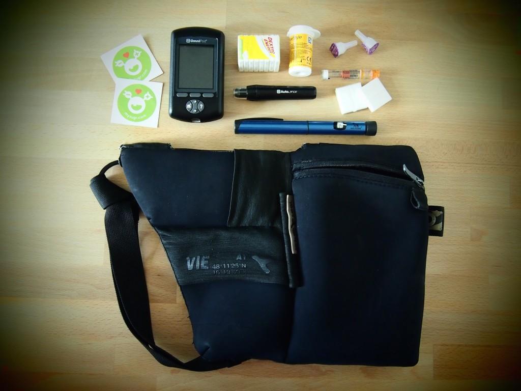 A cool urban carryall bag with some diabetes supplies around it