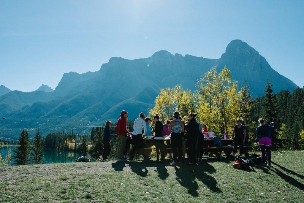 A group of people outside at a picnic table